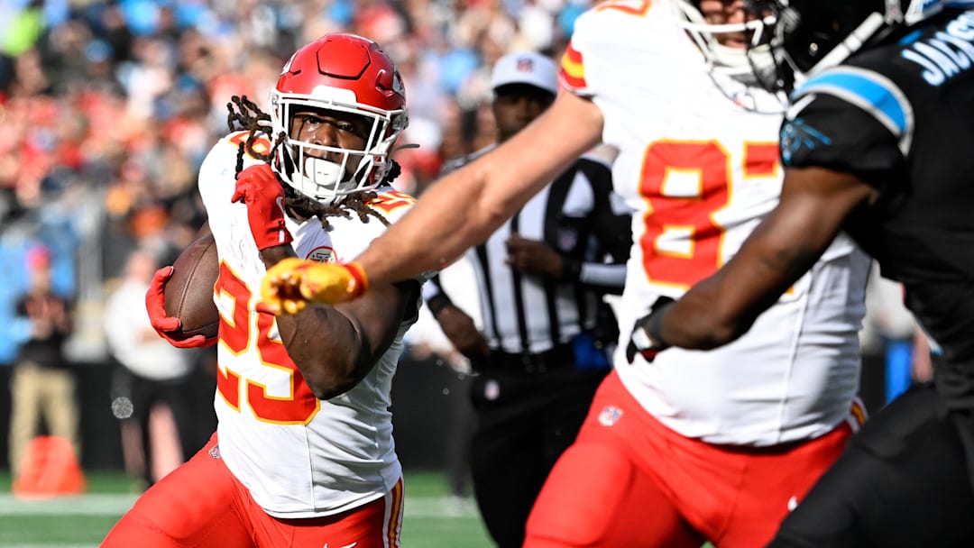 Nov 24, 2024; Charlotte, North Carolina, USA;  Kansas City Chiefs running back Kareem Hunt (29) runs as tight end Travis Kelce (87) blocks and Carolina Panthers cornerback Michael Jackson (2) defends in the second quarter at Bank of America Stadium. Mandatory Credit: Bob Donnan-Imagn Images