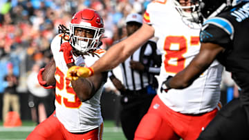 Nov 24, 2024; Charlotte, North Carolina, USA;  Kansas City Chiefs running back Kareem Hunt (29) runs as tight end Travis Kelce (87) blocks and Carolina Panthers cornerback Michael Jackson (2) defends in the second quarter at Bank of America Stadium. Mandatory Credit: Bob Donnan-Imagn Images
