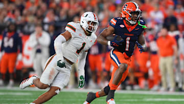 Nov 30, 2024; Syracuse, New York, USA; Syracuse Orange running back LeQuint Allen (1) runs with the ball against Miami Hurricanes linebacker Francisco Mauigoa (1) during the second half at the JMA Wireless Dome. Mandatory Credit: Rich Barnes-Imagn Images
