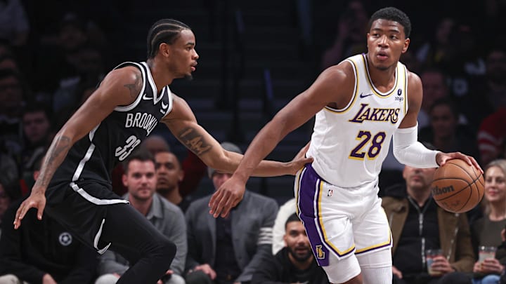 Mar 31, 2024; Brooklyn, New York, USA; Los Angeles Lakers forward Rui Hachimura (28) dribbles against Brooklyn Nets center Nic Claxton (33) during the first half at Barclays Center. Mandatory Credit: Vincent Carchietta-Imagn Images