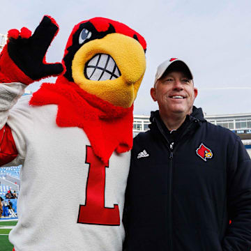 Nov 30, 2024; Lexington, Kentucky, USA; Louisville Cardinals head coach Jeff Brohm poses for a photo with the Cardinal mascot after the game against the Kentucky Wildcats at Kroger Field. Mandatory Credit: Jordan Prather-Imagn Images