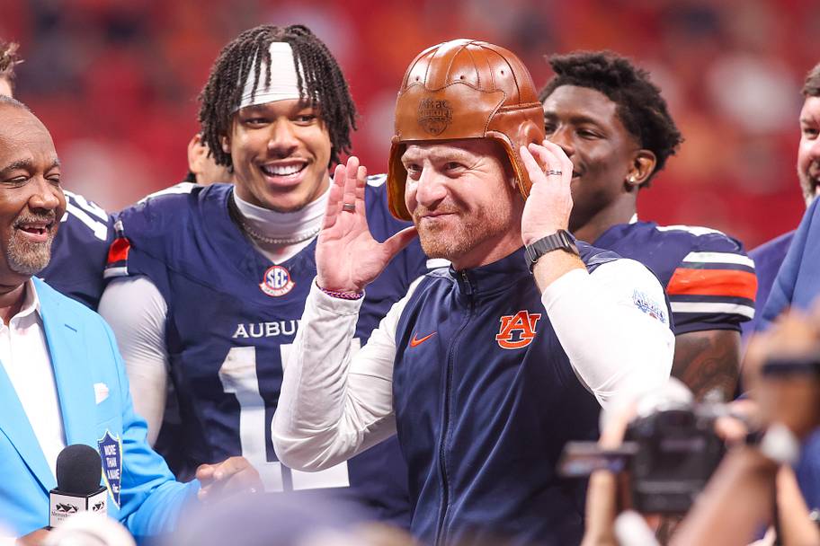 Auburn coach Alex Golesh wears the old leather helmet after a victory over Baylor.