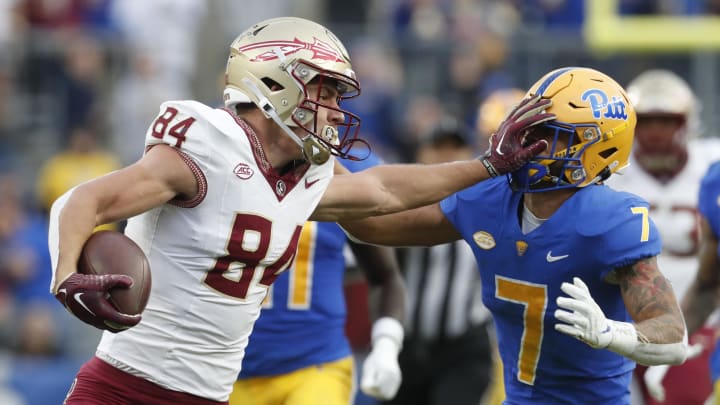 Nov 4, 2023; Pittsburgh, Pennsylvania, USA;  Florida State Seminoles tight end Kyle Morlock (84) stiff arms Pittsburgh Panthers defensive back Javon McIntyre (7) after a catch during the second quarter at Acrisure Stadium. Mandatory Credit: Charles LeClaire-USA TODAY Sports