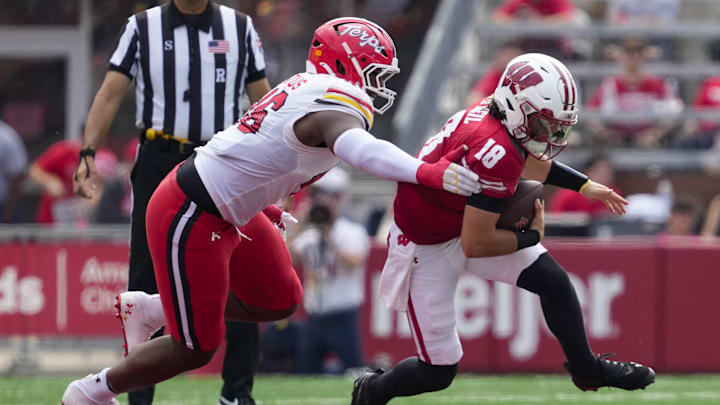 Sep 20, 2025; Madison, Wisconsin, USA;  Wisconsin Badgers quarterback Danny O'Neil (18) is tackled by jMaryland Terrapins defensive lineman Dillan Fontus (46)  during the second quarter at Camp Randall Stadium. Mandatory Credit: Jeff Hanisch-Imagn Images