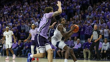 Jan 25, 2025; Manhattan, Kansas, USA; West Virginia Mountaineers guard Toby Okani (5) drives against Kansas State Wildcats forward Coleman Hawkins (33) in the second half at Bramlage Coliseum. Mandatory Credit: Scott Sewell-Imagn Images
