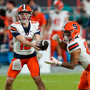 Nov 8, 2025; Miami Gardens, Florida, USA; Syracuse Orange quarterback Joseph Filardi (13) hands off to running back Jaden Hart (22) against the Miami Hurricanes during the fourth quarter at Hard Rock Stadium. Mandatory Credit: Jeff Romance-Imagn Images