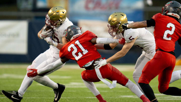 Dec 1, 2023; Canton, Ohio, USA;
Bishop Watterson's Ben Uhlenhake (42) attempts to make it past Toledo Central Catholic's Victor Singleton Jr. (21) as Christopher Bair (5) attempts to hold him back during their game on Friday, Dec. 1, 2023 at Tom Benson Hall of Fame Stadium for the Division III state finals.