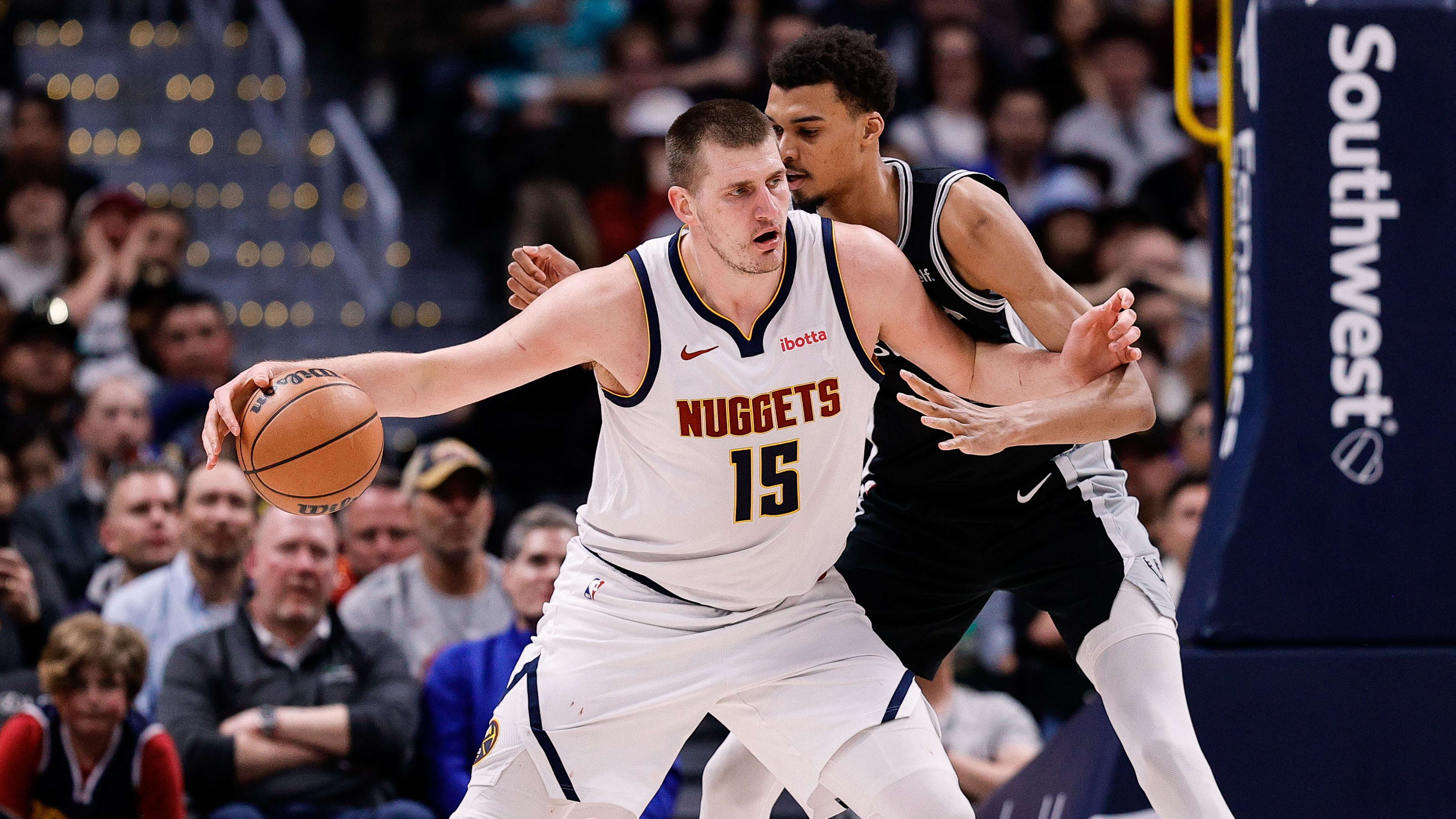 Nikola Jokic dribbles the ball as Victor Wembanyama defends in the paint.