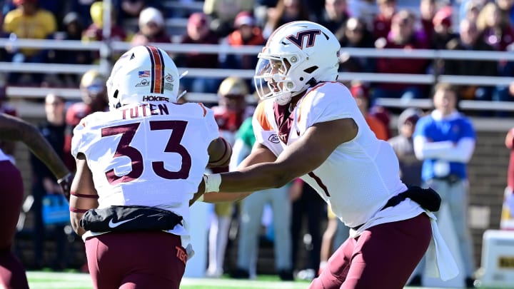 Nov 11, 2023; Chestnut Hill, Massachusetts, USA; Virginia Tech Hokies quarterback Kyron Drones (1) hands the ball to running back Bhayshul Tuten (33) during the first half against the Boston College Eagles at Alumni Stadium. Mandatory Credit: Eric Canha-USA TODAY Sports