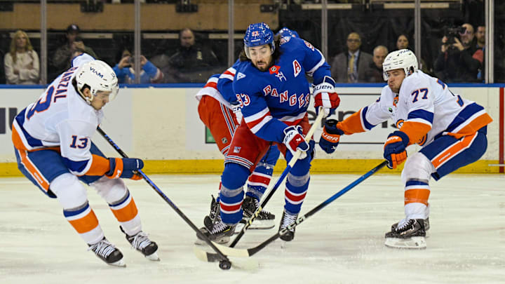 Jan 29, 2026; New York, New York, USA;  New York Islanders center Mathew Barzal (13) and defenseman Tony DeAngelo (77) battle New York Rangers center Mika Zibanejad (93) for a loose puck during the first period at Madison Square Garden. Mandatory Credit: Dennis Schneidler-Imagn Images