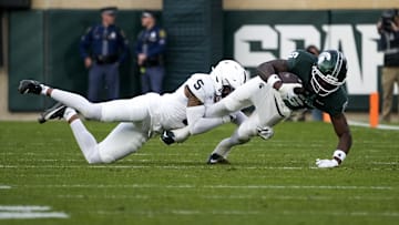 Nov 15, 2025; East Lansing, Michigan, USA; Penn State Nittany Lions cornerback Daryus Dixson (5) tackles Michigan State Spartans wide receiver Nick Marsh (6) after a catch in the second quarter at Spartan Stadium. Mandatory Credit: Brendan Mullin-Imagn Images