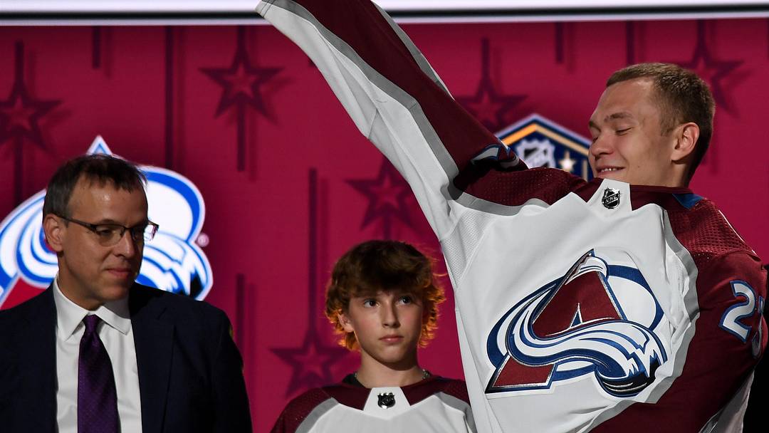 Jun 28, 2023; Nashville, Tennessee, USA; Colorado Avalanche draft pick Mikhail Gulyayev puts on his sweater after being selected with the thirty first pick in round one of the 2023 NHL Draft at Bridgestone Arena. Mandatory Credit: Christopher Hanewinckel-Imagn Images