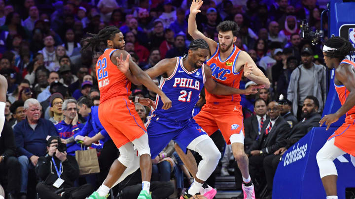 Apr 2, 2024; Philadelphia, Pennsylvania, USA; Philadelphia 76ers center Joel Embiid (21) battles for loose ball with Oklahoma City Thunder guard Cason Wallace (22) and forward Chet Holmgren (7) at Wells Fargo Center. Mandatory Credit: Eric Hartline-USA TODAY Sports