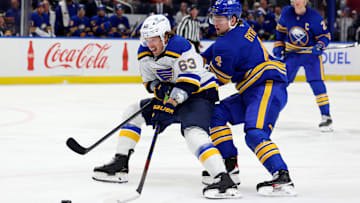 Nov 14, 2024; Buffalo, New York, USA;  St. Louis Blues left wing Jake Neighbours (63) skates with the puck as Buffalo Sabres defenseman Bowen Byram (4) defends during the first period at KeyBank Center. Mandatory Credit: Timothy T. Ludwig-Imagn Images