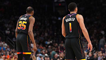Mar 21, 2025; Phoenix, Arizona, USA; Phoenix Suns forward Kevin Durant (35) and Phoenix Suns guard Devin Booker (1) look on against the Cleveland Cavaliers during the first half at Footprint Center. Mandatory Credit: Joe Camporeale-Imagn Images