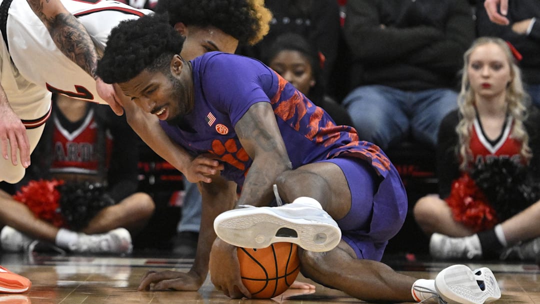Jan 7, 2025; Louisville, Kentucky, USA;  Clemson Tigers forward Chauncey Wiggins (7) scrambles for a loose ball with Louisville Cardinals guard Chucky Hepburn (24) during the first half at KFC Yum! Center. Mandatory Credit: Jamie Rhodes-Imagn Images