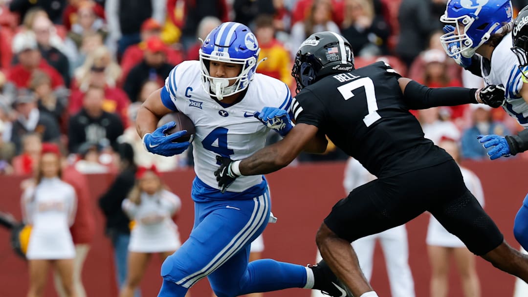 BYU's LJ Martin (4-white) runs the ball past Iowa State's Tre Bell (7-black) in a game at Jack Trice Stadium
