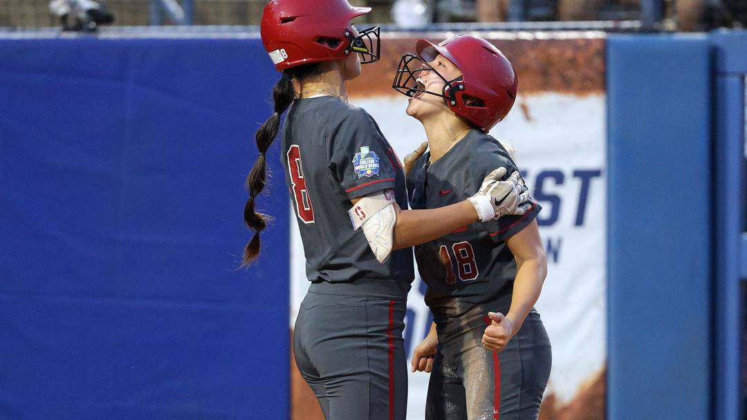 Stanford infielder Emily Jones, right, celebrates with outfielder Kyra Chan after scoring a run in the third inning of a Women's College World Series softball game between the Stanford Cardinal and the UCLA Bruins at Devon Park in Oklahoma City, Sunday, June 2, 2024. Stanford won 3-1.