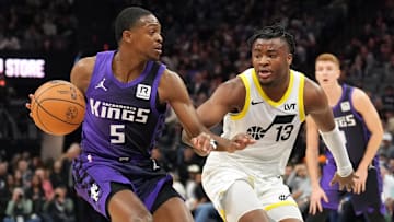 Dec 8, 2024; Sacramento, California, USA; Sacramento Kings guard De'Aaron Fox (5) dribbles against Utah Jazz guard Isaiah Collier (13) during the first quarter at Golden 1 Center. Mandatory Credit: Darren Yamashita-Imagn Images