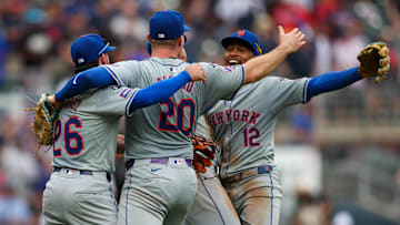Sep 30, 2024; Atlanta, Georgia, USA; New York Mets second baseman Eddy Alvarez (26) and first baseman Pete Alonso (20) and shortstop Francisco Lindor (12) celebrate after a victory over the Atlanta Braves that clinched a wild card playoff birth at Truist Park. Mandatory Credit: Brett Davis-Imagn Images