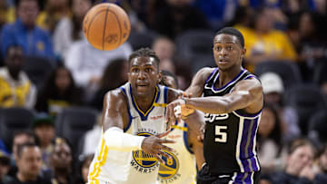 Oct 11, 2024; San Francisco, California, USA; Sacramento Kings guard De'Aaron Fox (5) passes away from defensive pressure by Golden State Warriors forward Kevon Looney (5) during the third quarter at Chase Center. Mandatory Credit: D. Ross Cameron-Imagn Images