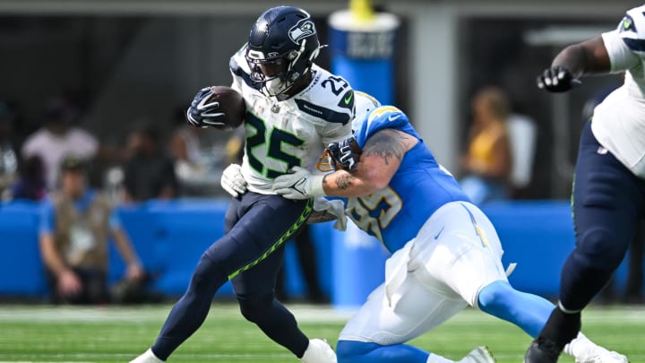 Aug 10, 2024; Inglewood, California, USA; Los Angeles Chargers tight end Donald Parham Jr. (89) tackles Seattle Seahawks running back Kenny McIntosh (25) during the first quarter at SoFi Stadium. Mandatory Credit: Jonathan Hui-USA TODAY Sports