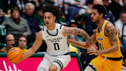 Feb 15, 2025; Fort Collins, Colorado, USA; Colorado State Rams guard Kyan Evans (0) controls the ball ahead of Wyoming Cowboys guard Dontaie Allen (11) in the first half at Moby Arena. Mandatory Credit: Isaiah J. Downing-Imagn Images
