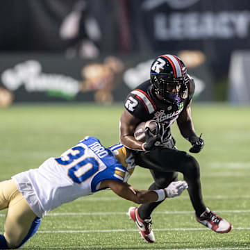 Jun 13, 2024; Ottawa, Ontario, CAN; Winnipeg Blue Bombers defensive back Tyrell Ford (30) tackles Ottawa REDBLACKS wide receiver Dominique Rhymes (15) in the first half at TD Place. Mandatory Credit: Marc DesRosiers-Imagn Images