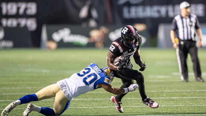 Jun 13, 2024; Ottawa, Ontario, CAN; Winnipeg Blue Bombers defensive back Tyrell Ford (30) tackles Ottawa REDBLACKS wide receiver Dominique Rhymes (15) in the first half at TD Place. Mandatory Credit: Marc DesRosiers-Imagn Images