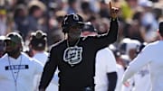 Nov 16, 2024; Boulder, Colorado, USA; Colorado Buffaloes head coach Deion Sanders calls in a play in the first quarter against the Utah Utes at Folsom Field. Mandatory Credit: Ron Chenoy-Imagn Images