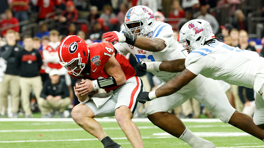 Ole Miss Rebels defensive tackle Zxavian Harris (51) and defensive end Kam Franklin (5) sack Georgia Bulldogs quarterback Gunner Stockton (14)