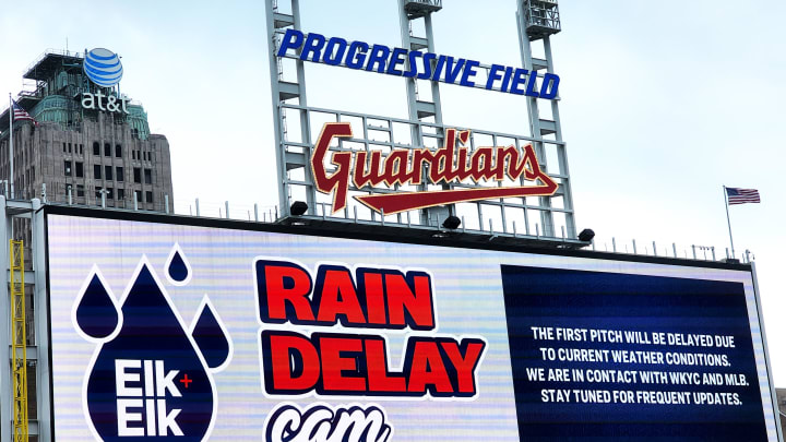 A rain delay announcement appears on the scoreboard before a game.