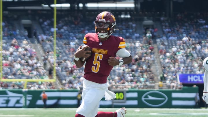 Aug 10, 2024; East Rutherford, New Jersey, USA; Washington Commanders quarterback Jayden Daniels (5) rushes for a touchdown during the first quarter against the New York Jets at MetLife Stadium. Mandatory Credit: Lucas Boland-USA TODAY Sports