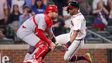 Atlanta Braves outfielder Eddie Rosario (9) scores a run past Cincinnati Reds catcher Austin Wynns (38) in the ninth inning at Truist Park.