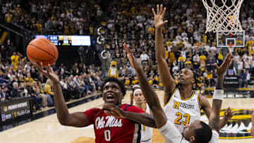 Jan 25, 2025; Columbia, Missouri, USA; Mississippi Rebels forward Malik Dia (0) shoots against Missouri Tigers guard Tamar Bates (2) and guard Aidan Shaw (23) during the first half at Mizzou Arena. Mandatory Credit: Jay Biggerstaff-Imagn Images