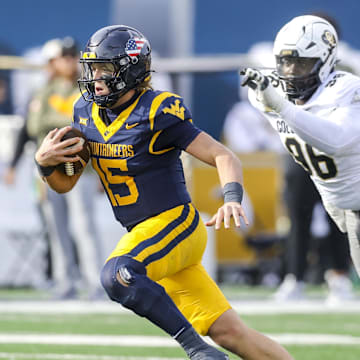 Nov 8, 2025; Morgantown, West Virginia, USA; West Virginia Mountaineers quarterback Scotty Fox Jr. (15) runs out of the pocket during the second quarter against the Colorado Buffaloes at Milan Puskar Stadium. Mandatory Credit: Ben Queen-Imagn Images