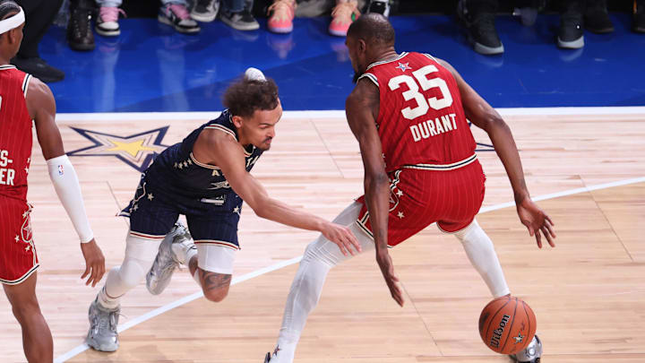 Feb 18, 2024; Indianapolis, Indiana, USA; Eastern Conference guard Trae Young (11) of the Atlanta Hawks dribbles past Western Conference forward Kevin Durant (35) of the Phoenix Suns during the second quarter in the 73rd NBA All Star game at Gainbridge Fieldhouse. Mandatory Credit: Trevor Ruszkowski-Imagn Images