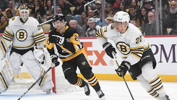 Hockey player in white uniform skates with the puc