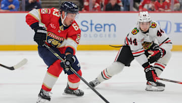 Oct 7, 2025; Sunrise, Florida, USA; Florida Panthers left wing Brad Marchand (63) moves the puck against Chicago Blackhawks defenseman Wyatt Kaiser (44) during the first period at Amerant Bank Arena. Mandatory Credit: Sam Navarro-Imagn Images