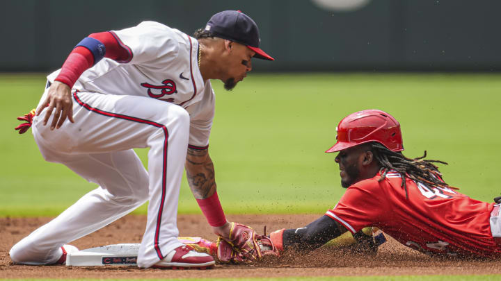 Jul 24, 2024; Cumberland, Georgia, USA; Cincinnati Reds shortstop Elly De La Cruz (44) steals second base under the tag by Atlanta Braves shortstop Orlando Arcia (11) during the first inning at Truist Park. Mandatory Credit: Dale Zanine-USA TODAY Sports