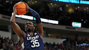 Mar 23, 2025; Raleigh, NC, USA; Connecticut Huskies center Samson Johnson (35) dunks the ball during the first half as Florida Gators guard Alijah Martin (15) defends in the second round of the NCAA Tournament at Lenovo Center. Mandatory Credit: Bob Donnan-Imagn Images
