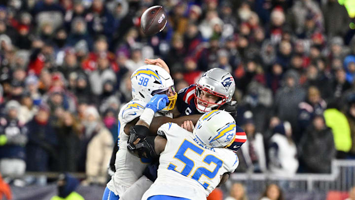 Jan 11, 2026; Foxborough, MA, USA; Los Angeles Chargers linebacker Odafe Oweh (98) and Los Angeles Chargers linebacker Khalil Mack (52) tackle New England Patriots quarterback Drake Maye (10) as he throws a pass during the second half in an AFC Wild Card Round game at Gillette Stadium. Mandatory Credit: Eric Canha-Imagn Images