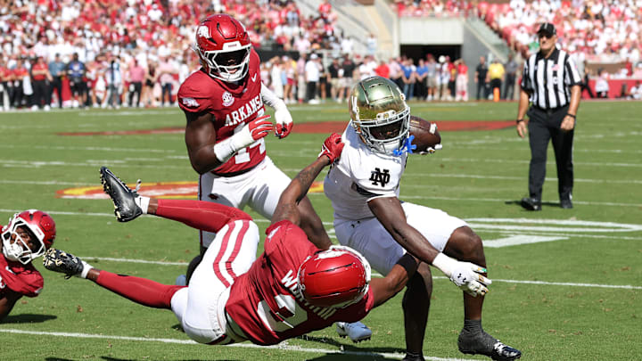 Sep 27, 2025; Fayetteville, Arkansas, USA; Notre Dame Fighting Irish running back Jeremiyah Love (4) rushes during the first quarter as Arkansas Razorbacks defensive back Larry Worth III (3) tackles at Donald W. Reynolds Razorback Stadium. Mandatory Credit: Nelson Chenault-Imagn Images