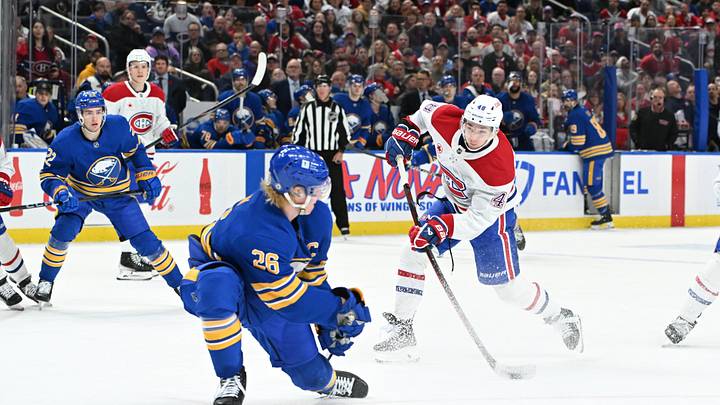 Nov 11, 2024; Buffalo, New York, USA; Montreal Canadiens defenseman Lane Hutson (48) shoots the puck with Buffalo Sabres defenseman Rasmus Dahlin (26) defending in the third period at KeyBank Center. Mandatory Credit: Mark Konezny-Imagn Images