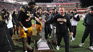 Nov 29, 2025; Fayetteville, Arkansas, USA; Missouri Tigers head coach Eli Drinkwitz celebrates with defensive end Zion Young (9) and the Battle Line trophy after a game against the Arkansas Razorbacks at Donald W. Reynolds Razorback Stadium. Missouri won 31-17. Mandatory Credit: Nelson Chenault-Imagn Images