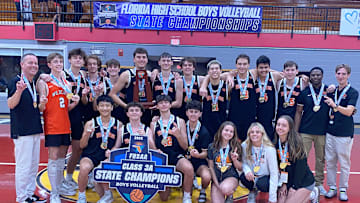 Winter Park players, coaches and staff gather after winning the Class 3A volleyball state championship Saturday at Polk State College.