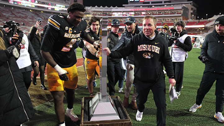 Nov 29, 2025; Fayetteville, Arkansas, USA; Missouri Tigers head coach Eli Drinkwitz celebrates with defensive end Zion Young (9) and the Battle Line trophy after a game against the Arkansas Razorbacks at Donald W. Reynolds Razorback Stadium. Missouri won 31-17. Mandatory Credit: Nelson Chenault-Imagn Images