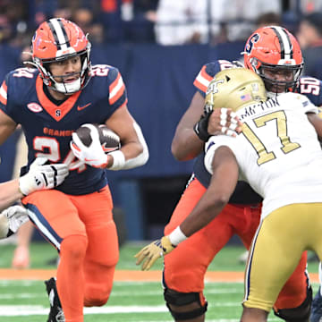 Sep 7, 2024; Syracuse, New York, USA; Syracuse Orange running back Will Nixon (24) runs through a gap in the Georgia Tech Yellow Jackets defense in the third quarter at the JMA Wireless Dome. Mandatory Credit: Mark Konezny-Imagn Images