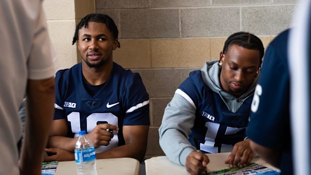 Penn State running backs Nick Singleton and Kaytron Allen sign autographs before the start of the Blue-White game.
