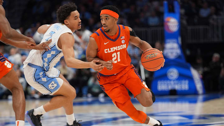 Mar 12, 2026; Charlotte, NC, USA; Clemson Tigers guard Ace Buckner (21) dribbles the ball guarded by North Carolina Tar Heels guard Seth Trimble (7) during the second half.